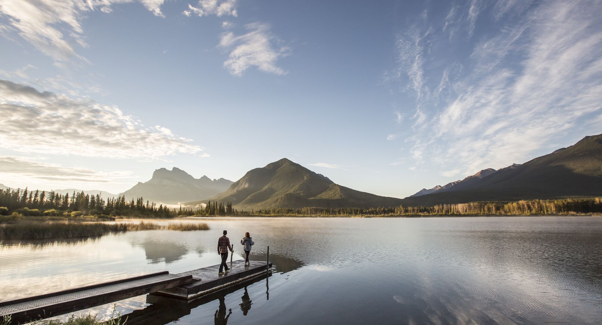 Two people on the dock at Vermilion Lakes for sunrise in the summer